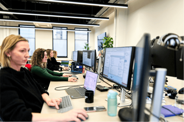 Row of desks showing people working